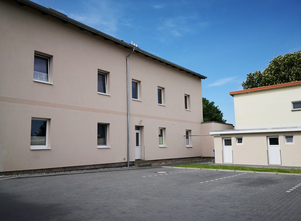Hof mit Nebengebäuden und Parkplätzen